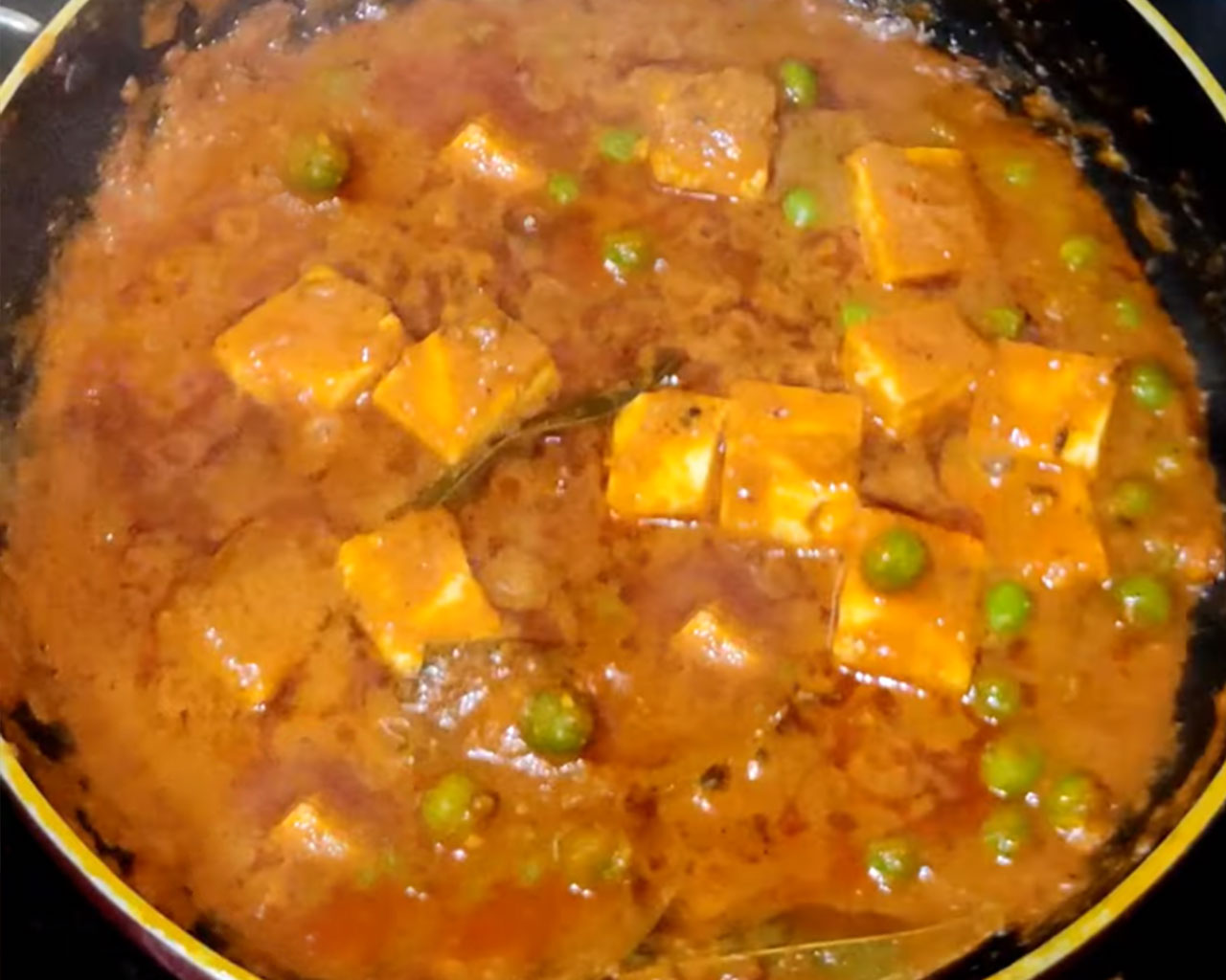 Cooked matar paneer curry with soft paneer cubes and green peas in a thick, spiced tomato gravy