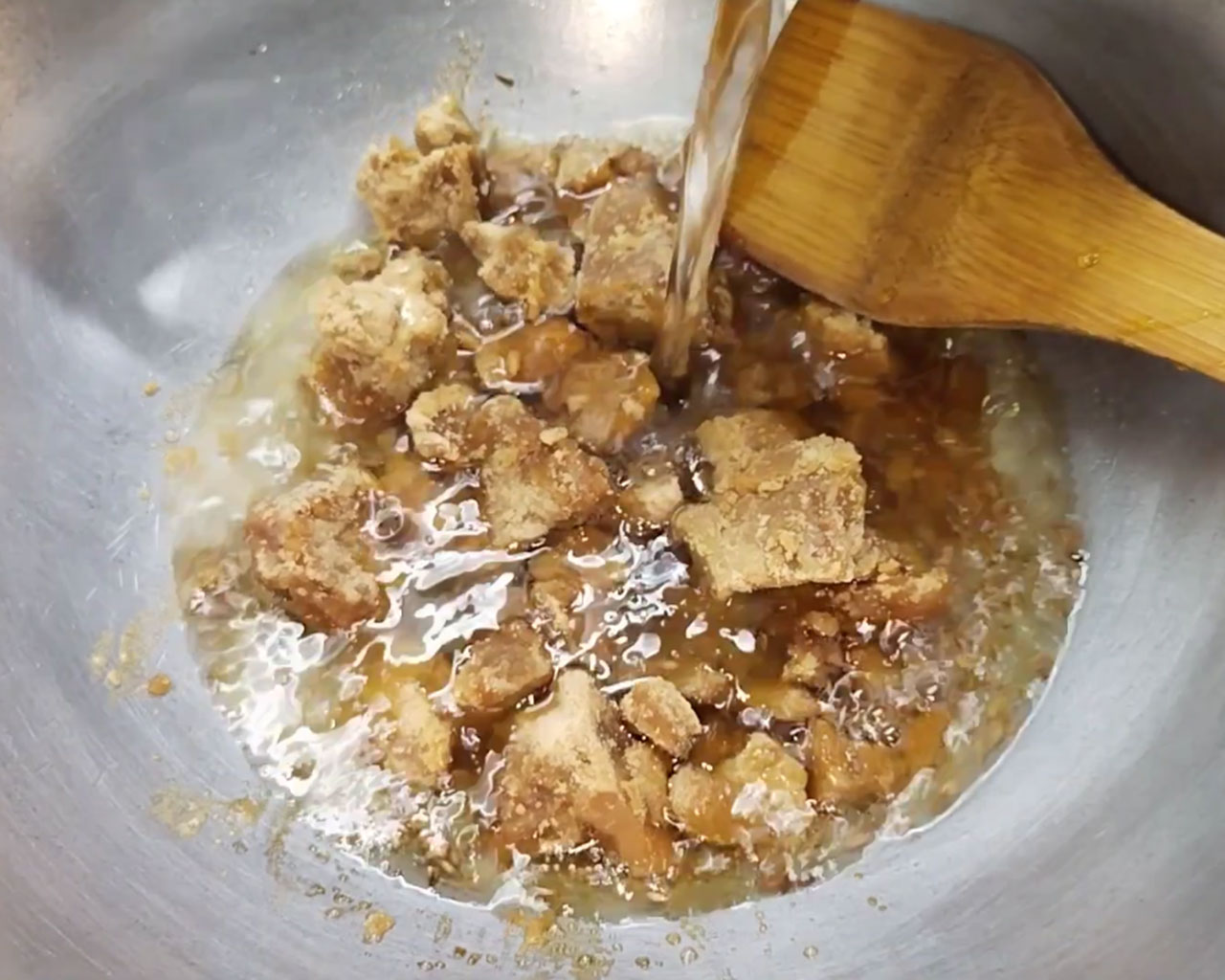 Mixing water with jaggery to create syrup for sweet tamarind chutney