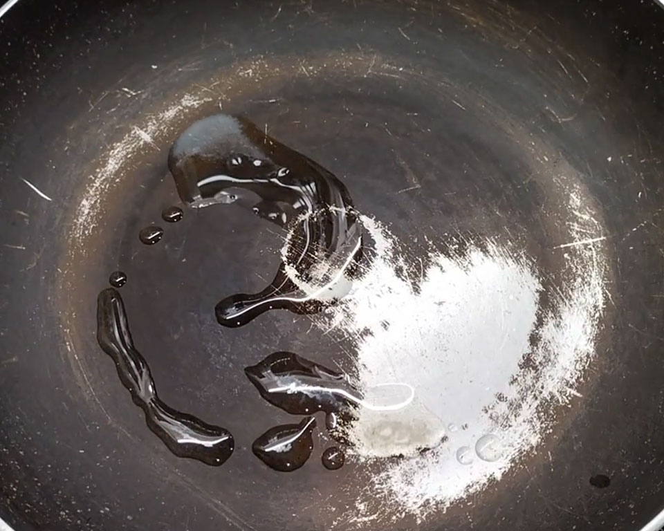 Heating ghee in a non-stick pan for making coconut ladoo at home