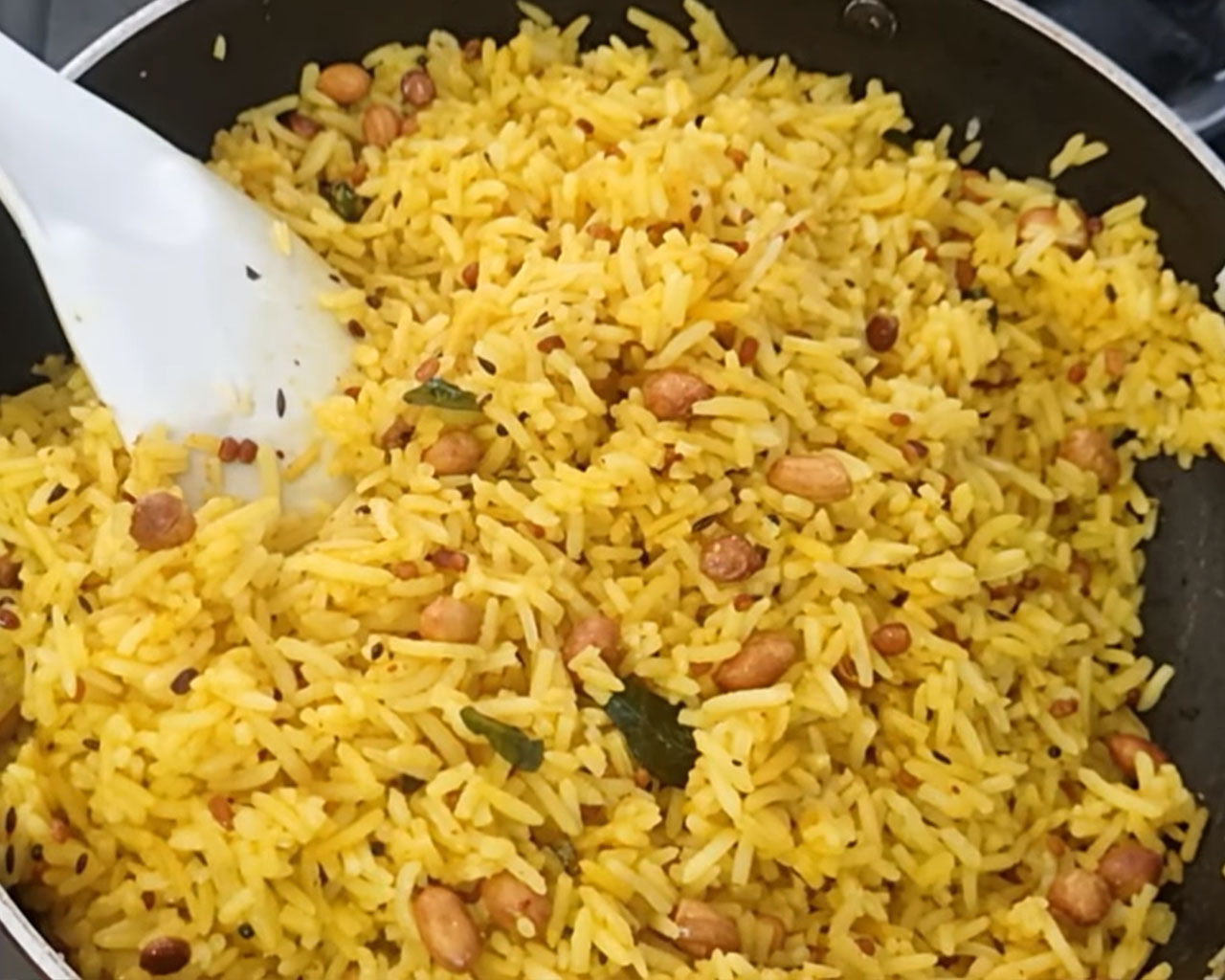 Rice mixed with turmeric for making lemon rice
