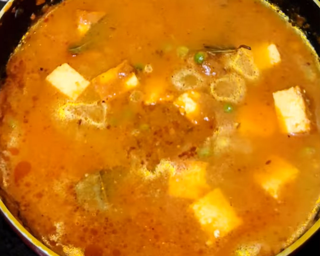 Matar paneer simmering on low heat to allow the flavors to blend and the gravy to thicken