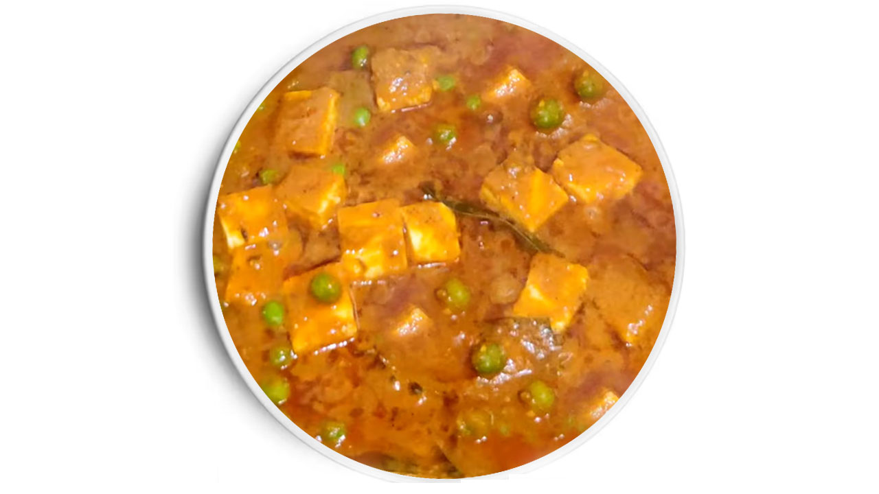 Matar paneer curry with soft paneer cubes and green peas in a thick, spiced tomato gravy on a plate