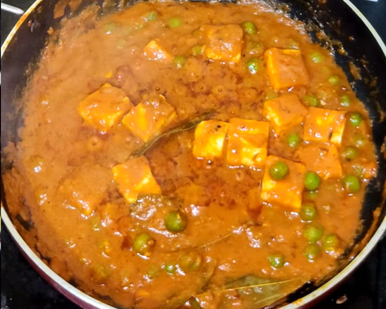 Paneer cubes mixed with green peas in a rich tomato-based gravy for matar paneer