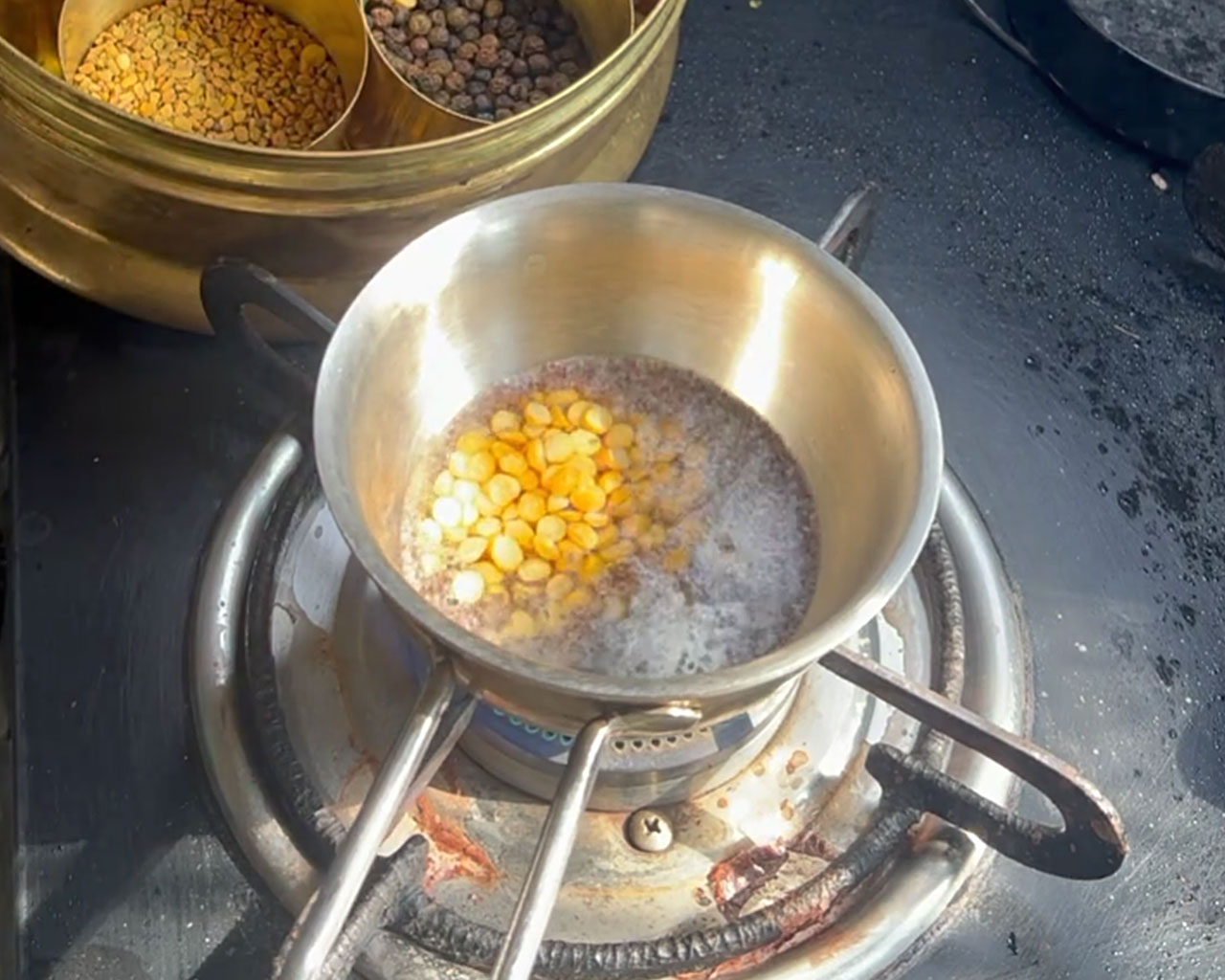 Mustard seeds and chana dal being added to hot oil for South Indian tadka for onion chutney