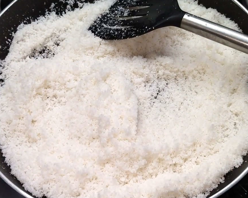 Roasting desiccated coconut in ghee on medium flame for ladoo