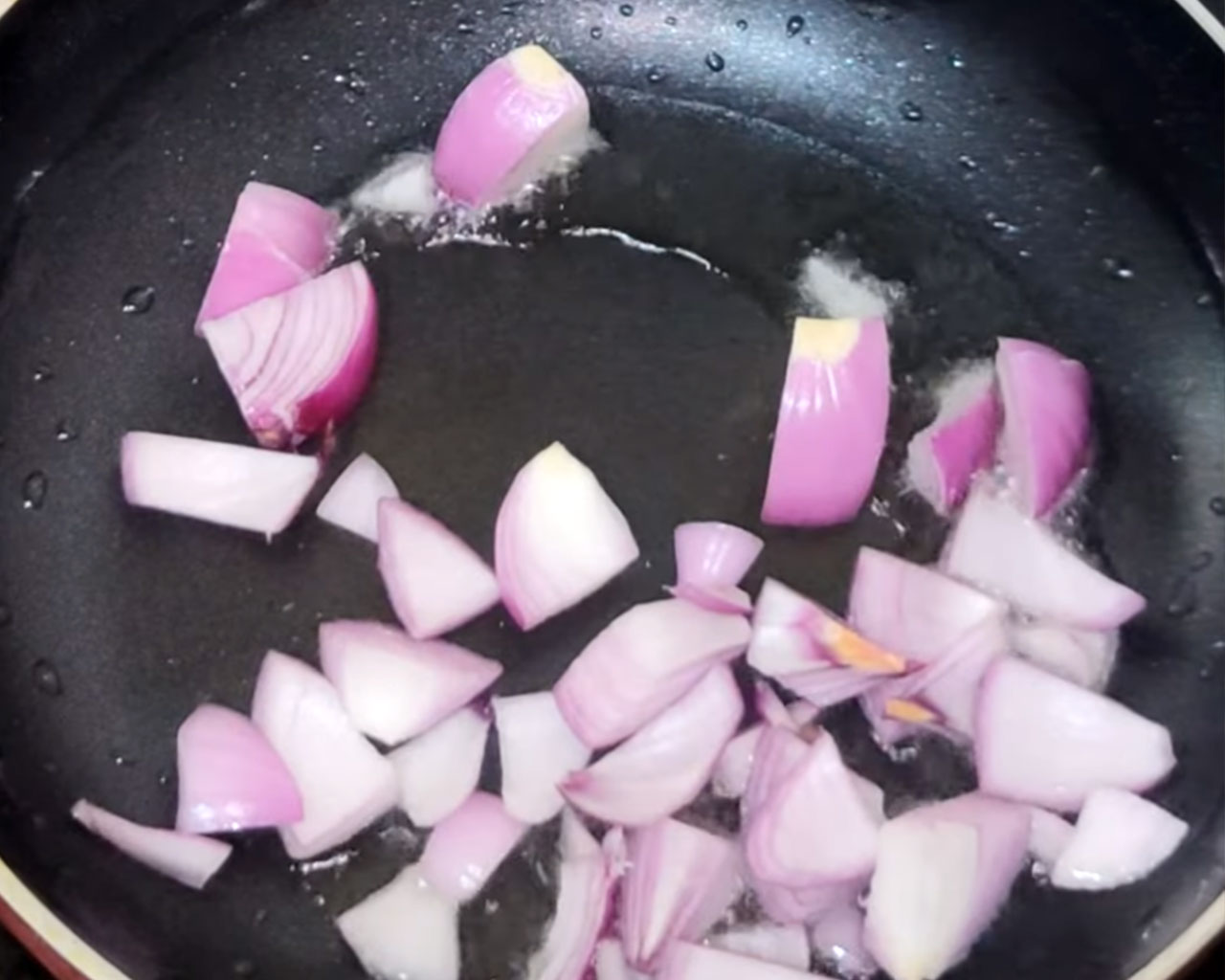 Chopped onions sautéing in oil for making matar paneer masala paste