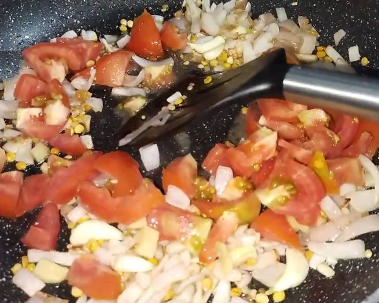 Adding chopped tomatoes and ginger to the sautéed lentils and onions