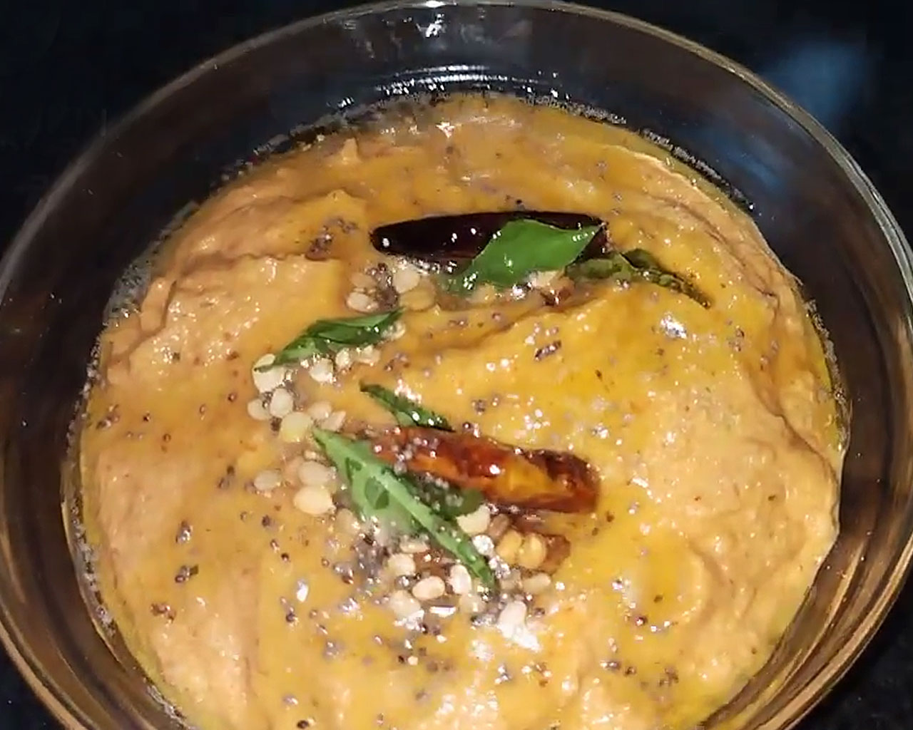 tomato chutney with tadka in a glass bowl