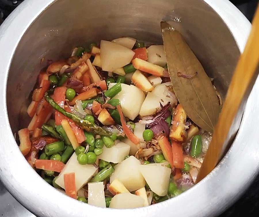 Making vegetable masala pulao.