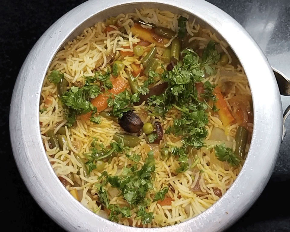 Cooked masala veg pulao garnished with chopped coriander and ghee