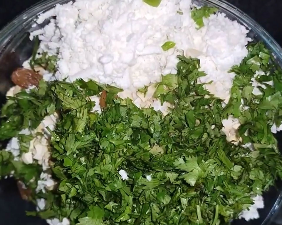 Mixing mashed potatoes, paneer, cashews, and spices to form malai kofta dough