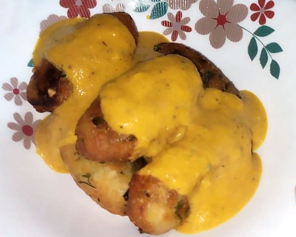 Finishing Malai Kofta gravy with cream and spices