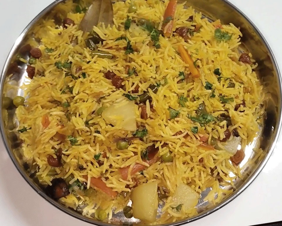 Masala vegetable pulao served with cucumber raita, pickle, and papad