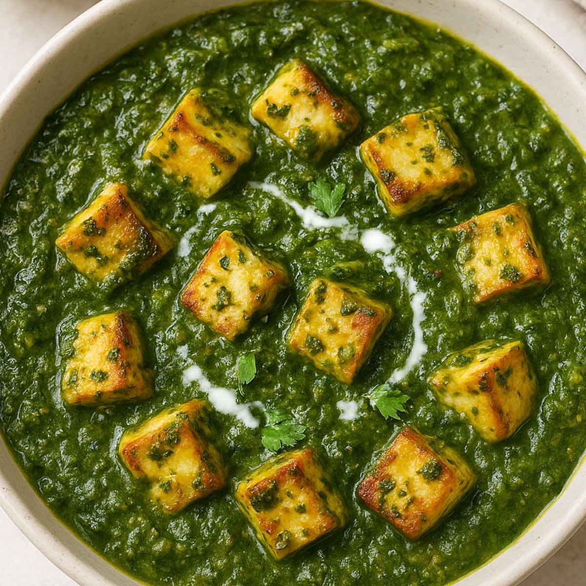 Close-up of saag paneer in a bowl, creamy spinach-based curry with cottage cheese cubes, a classic Punjabi recipe.
