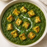 Delicious saag paneer curry served in a bowl, made with fresh spinach purée, soft paneer cubes, and traditional Indian masala, enjoyed with naan or rice.