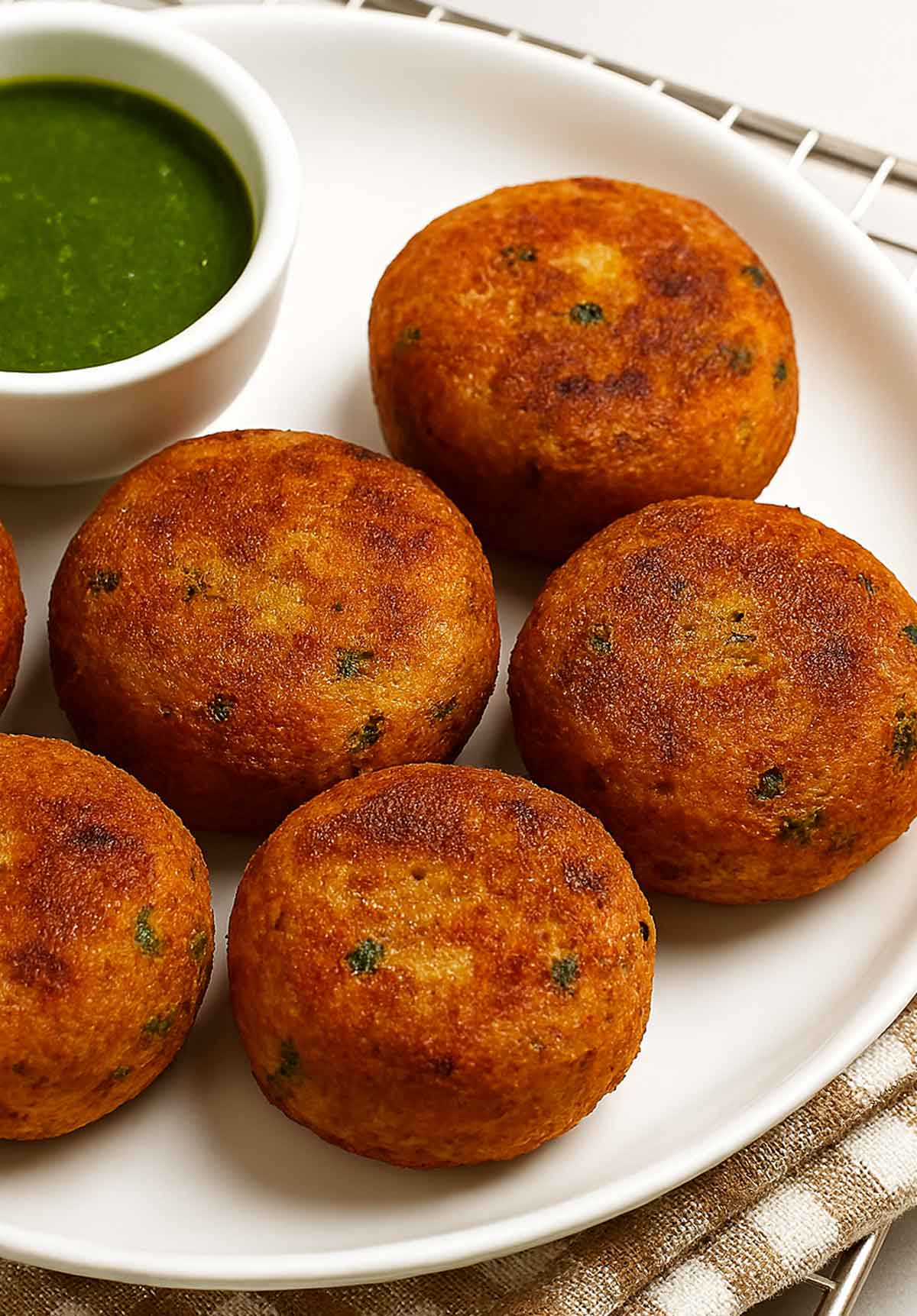 Spiced potato patties fried (aloo tikki) recipe served on plate with fresh herbs