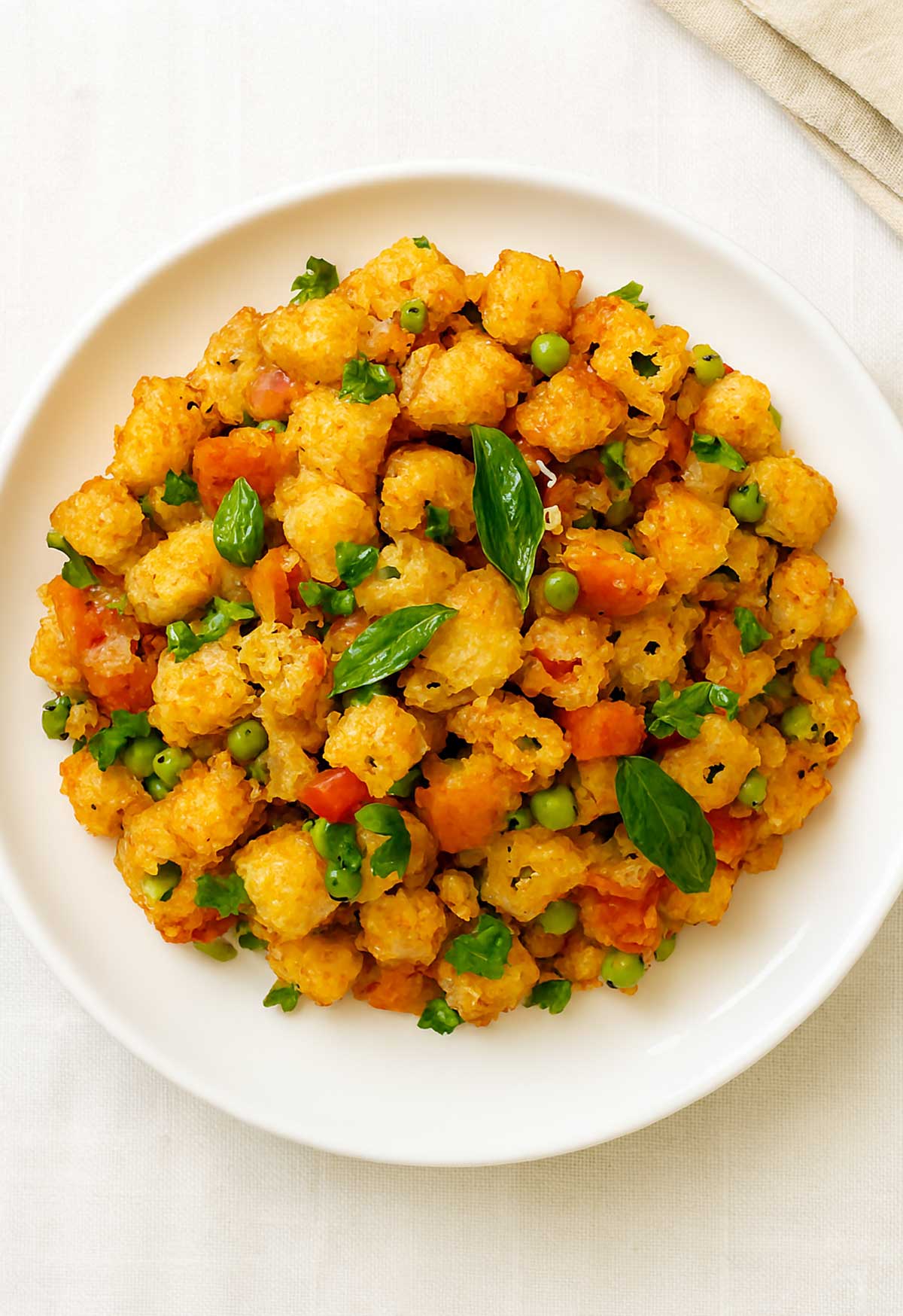 Bread Upma Indian breakfast recipe made with carrots and peas served on a white plate