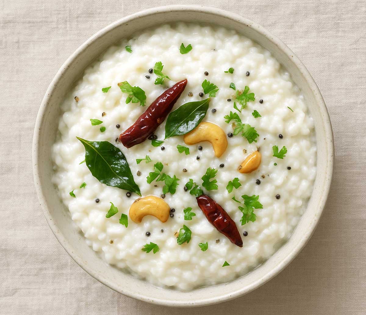 thayir sadam in a ceramic bowl garnished with curry leaves and red chili, traditional South Indian yogurt rice
