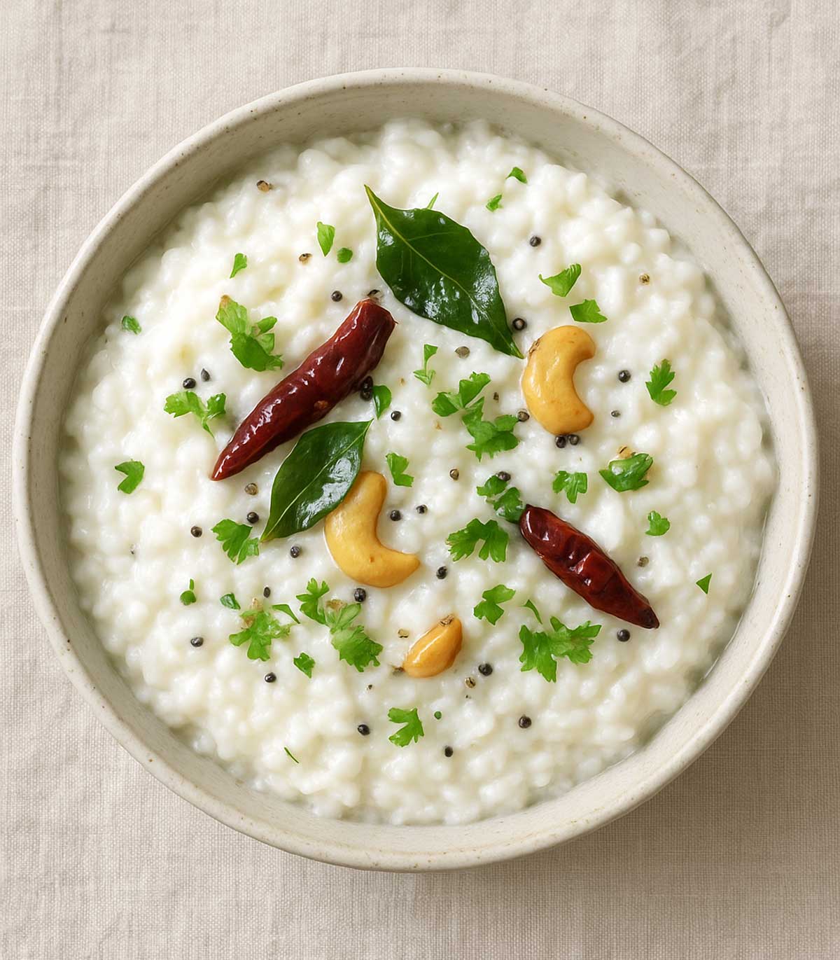 Healthy Indian curd rice served in a ceramic bowl, topped with red chili, cashews, and curry leaves, traditional South Indian Thayir Sadam recipe for dinner.