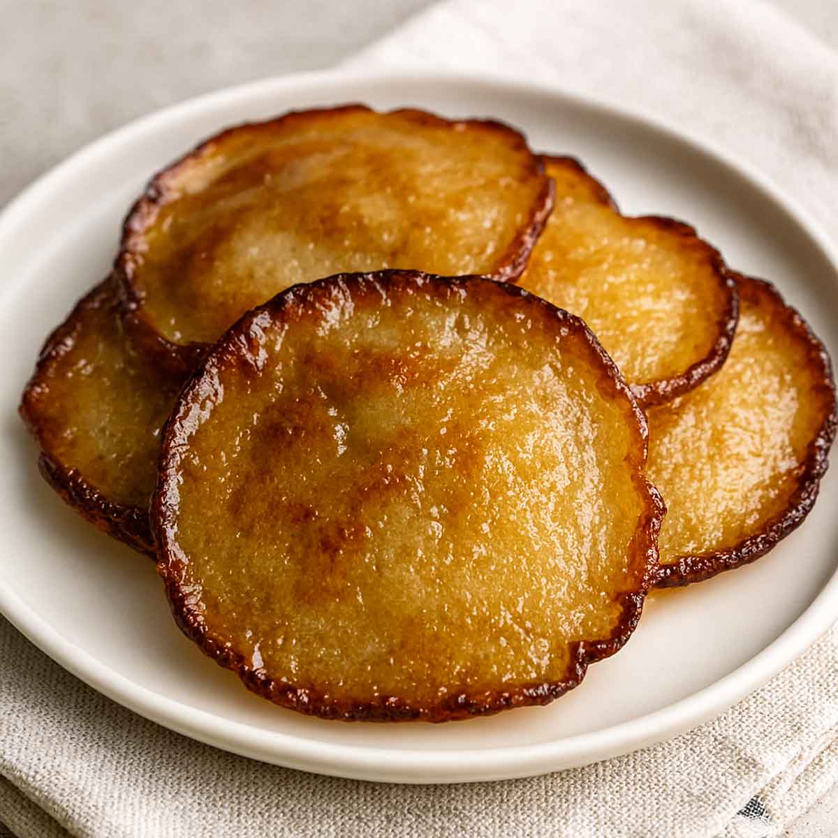Golden brown Malpua drizzled with sugar syrup