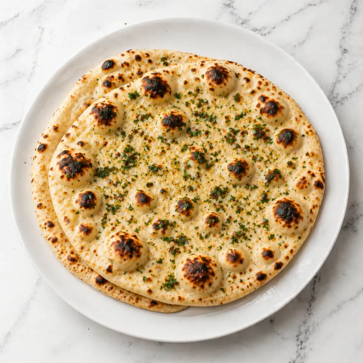 Garlic naan cooked without tandoor served on white plate on kitchen top
